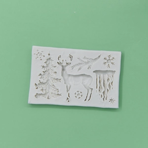 White silicone Christmas mold featuring reindeer and snowflakes on a green background