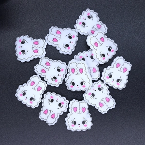 Flat lay of multiple cute resin rabbit charms for DIY phone case and accessory crafts