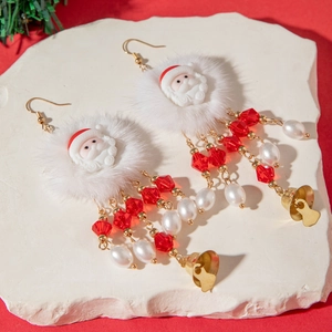 Detail of Christmas Santa earrings with fluffy white fur, red beads and gold bells