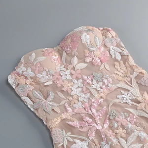 Close-up of intricate pink sequin floral embroidery on nude mesh of a strapless dress