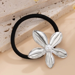 Close-up of alloy flower hair tie with faux pearl on natural stone background