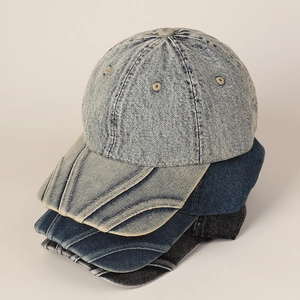 Detailed stack of washed denim baseball caps showing distressed textures and stitching