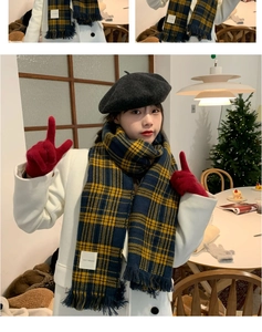 Detail of yellow and blue plaid scarf featuring soft fringe and authentic fabric label