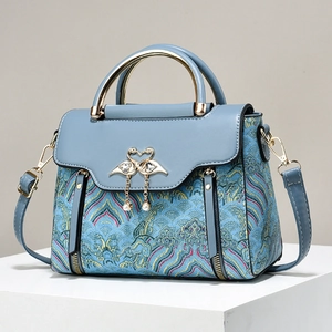 Blue embroidered handbag with contrast leather, gold swan buckle and pearl tassel