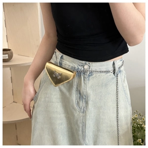 Close-up of golden triangular mini bag with silver butterfly buckle and chain strap