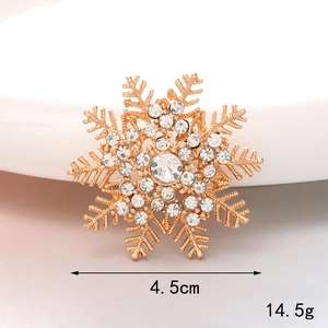 Detailed view of a gold snowflake charm with crystals showing 4.5cm size and 14.5g weight