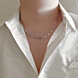 Close-up of minimalist silver titanium steel chain necklace on male model neck