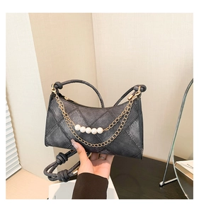 Détail du sac croissant en denim gris foncé avec chaînes dorées et grosses perles blanches