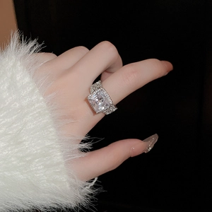 Gros plan d'une bague en argent avec un zircon carré et des micro-pavés de diamants