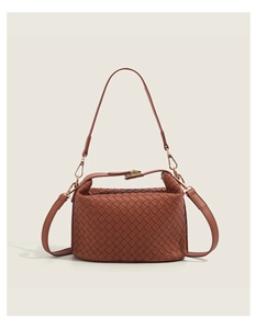 Close-up of caramel woven leather handbag with gold buckles and detachable straps