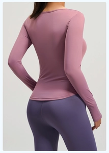 Dettaglio di maglia yoga a maniche lunghe e leggings a vita alta in morbidi colori pastello