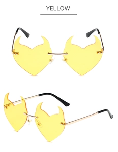 Macro detail of yellow heart-shaped devil sunglasses with gold metal frame