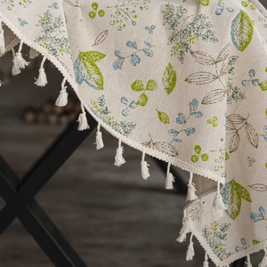 Detailed macro view of cotton linen tablecloth featuring plant patterns and fringe edges