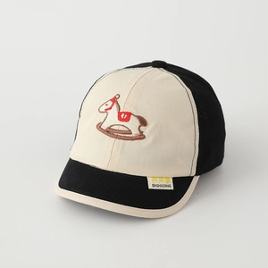 Macro shot of the soft cotton fabric and embroidered rocking horse on child baseball cap
