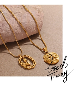 Detailed macro view of vintage tulip pendants and gold chain necklaces on texture