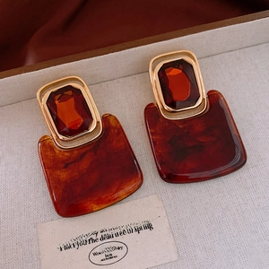 Detail of square vintage amber tortoiseshell resin earrings with gold metal frame