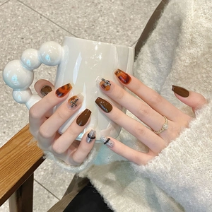 Amber tortoiseshell press-on nails with dark brown finish and glitter in coffin shape