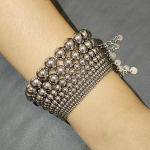 Macro shot of silver stainless steel stretch bracelet featuring graduated metal beads