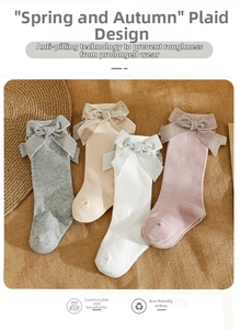 Close-up of knit cotton socks with large glittery bows in gray, cream, white, and pink