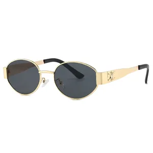 Oval gold metal frame sunglasses with dark grey lenses and embossed decorative temples