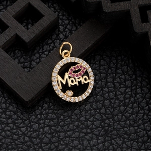 Detail of gold MAMA pendant with red lips and crystals on dark leather background