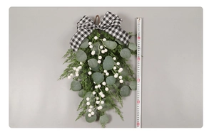 Close-up of 50cm Christmas eucalyptus swag with checkered bow and white berries