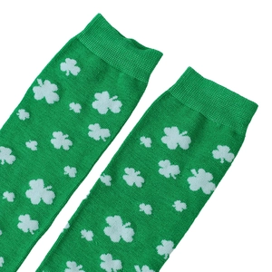 Close-up of St. Patrick's Day green over-knee socks with clover patterns and knit texture