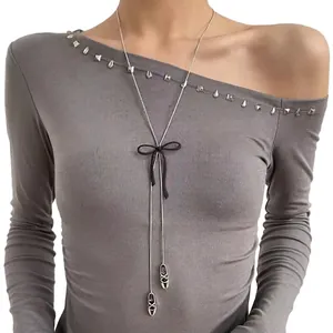 Dettaglio della collana lunga argento con fiocco in seta nera e ciondoli a scarpetta
