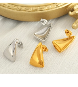 Detailed view of 3D geometric triangle stud earrings in gold and silver polished finish
