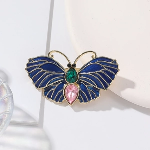 Détail d'une broche papillon en émail bleu avec des pierres précieuses colorées