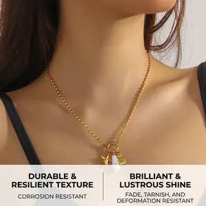 Detail of gold necklace with starfish, pineapple charms and baroque pearl on rope chain