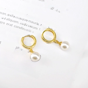 Detailed macro shot of S925 silver stamp on gold drop earrings with white pearls