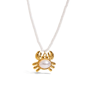Detail von 18K Gold Edelstahl Krabbenanhänger mit Perle auf weißer Perlenkette