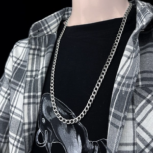 Close-up of polished silver stainless steel Cuban link chain worn by a male model
