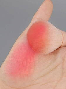 Macro detail of soft pink gradient makeup brush bristles showing pigment payoff on skin