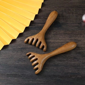 Sandalwood five-finger head massage combs shown in pairs on a rustic wooden surface