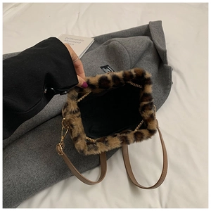 Macro view showing leopard faux fur texture and leather handle of bucket bag