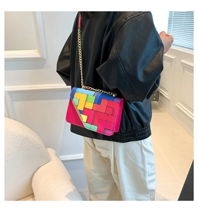 Detail of colorful Tetris-style patchwork pattern on crossbody bag with gold chain strap