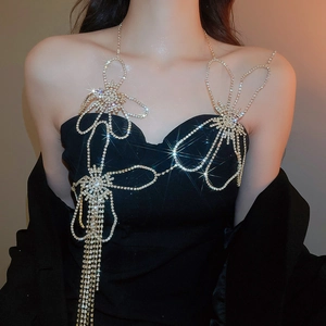 Detail of silver rhinestone body chain with floral pattern and sparkling bow tassel