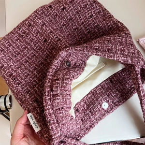 Vista dettagliata della trama del tessuto in tweed rosa e viola con chiusura magnetica