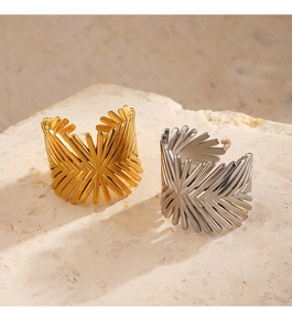 Detail of minimalist geometric open rings in gold and silver finish on stone texture