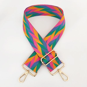 Detail of colorful geometric woven bag strap with golden metal swivel hooks and buckle