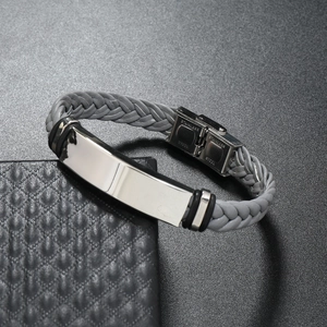 Macro shot of grey braided leather bracelet with polished stainless steel ID tag and clasp