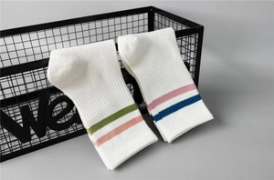 Detailed texture of white cotton mid-calf socks with green and blue sporty stripes