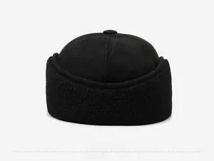 Detail of black winter trapper hat showing thick faux shearling trim and suede texture