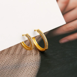 Close-up of gold s925 sterling silver hoop earrings with pave set sparkling zircons