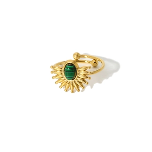 Detailed view of vintage gold ring with sunburst design and green striped malachite gem