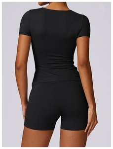 Rear view of tight-fit black yoga set featuring short sleeve t-shirt and high waist shorts