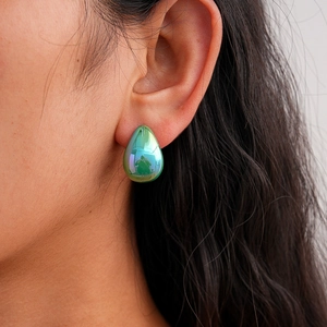Detail view of water-drop green acrylic earring with metallic finish on model ear