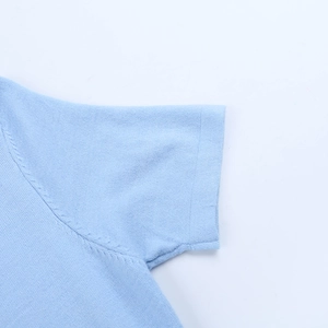 Gros plan détaillé des coutures et de la texture d'une robe en maille bleue sur fond blanc
